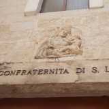 Dei due portali in legno il primo, pi� piccolo, � sormontato da un architrave su cui si innesta una formella scolpita con la Madonna col Bambino